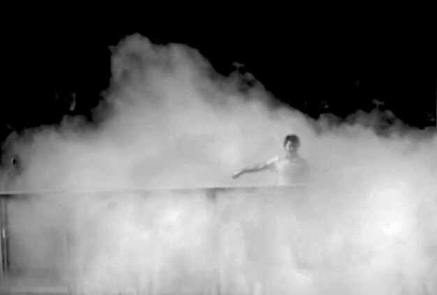 Photo man walking amidst smoke