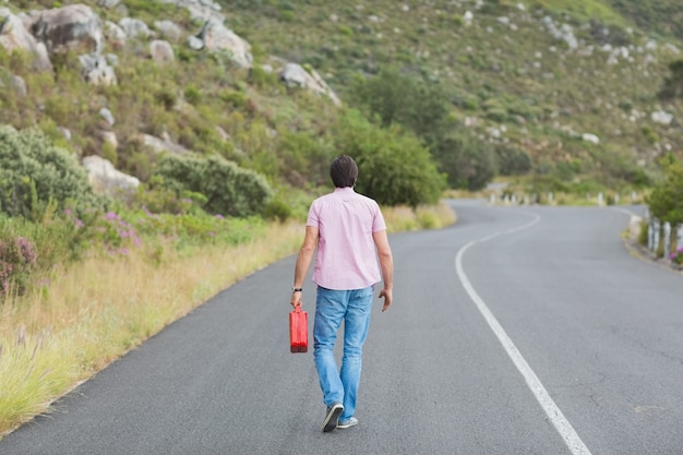 Uomo che cammina via tenendo petrolcan