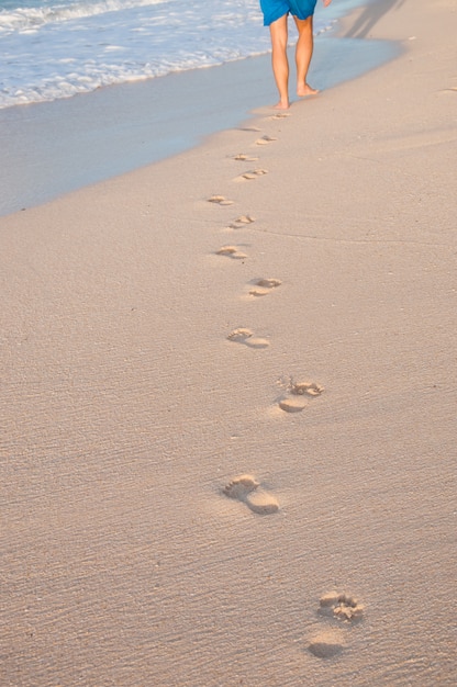 Man walking on the beach leaving footsteps