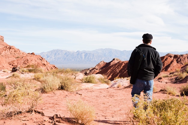 Foto uomo che cammina nel paesaggio desertico