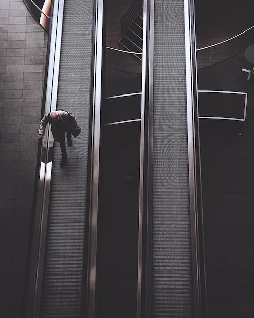 Foto uomo che cammina su una scala mobile