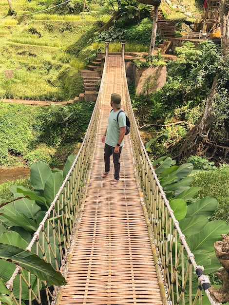 Foto uomo che cammina su un ponte pedonale