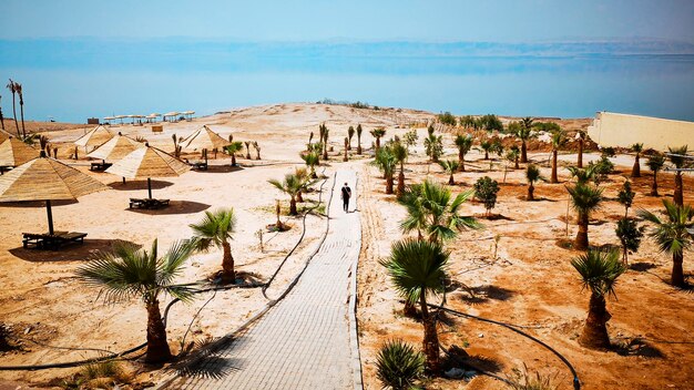 Photo man walking on a footpath directed to the sea dead sea jordan