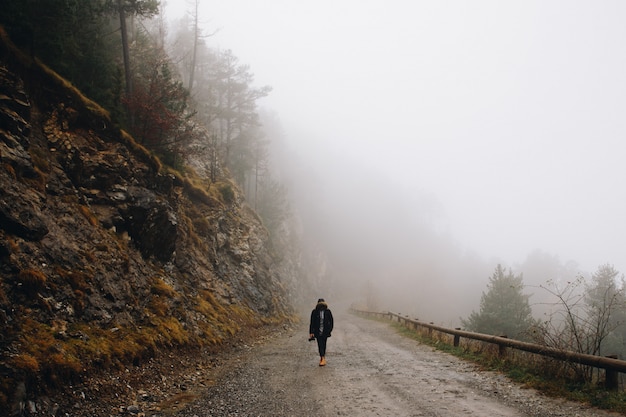 Man walking in the mountain on a foggy day in the mountain in winter