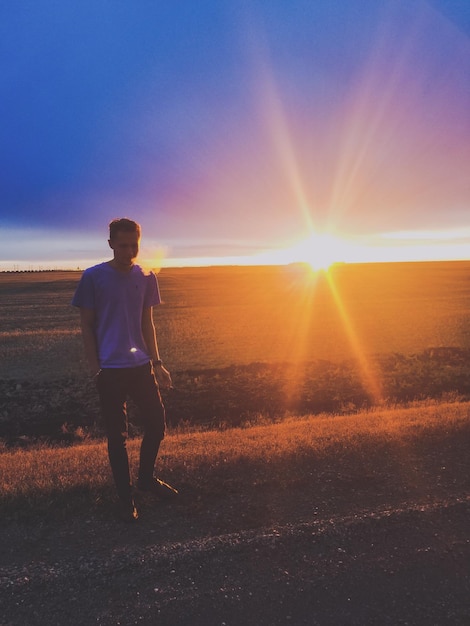 Foto uomo che cammina sulla strada contro un cielo nuvoloso durante il tramonto