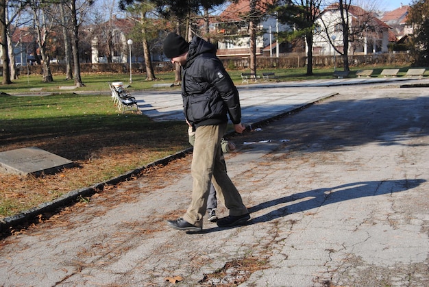 Foto uomo che cammina sulla strada durante una giornata di sole