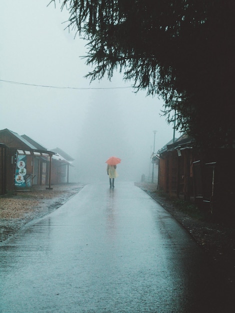 雨季の道路を歩く男