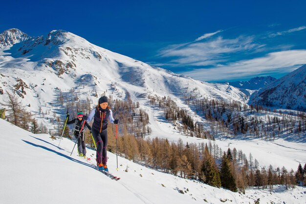 Man walking on snow covered mountain against sky