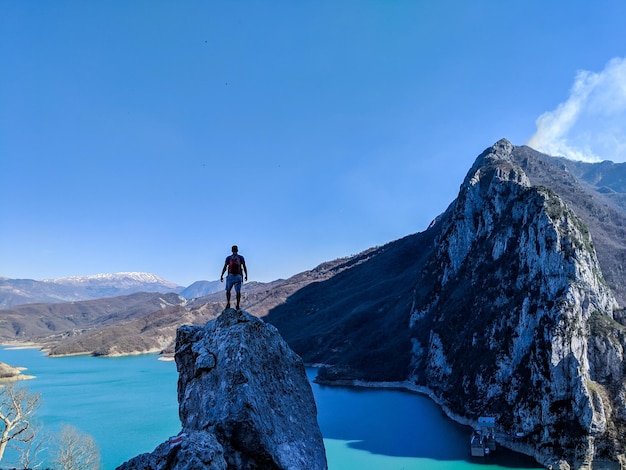 Man walking on snowcapped mountain against sky