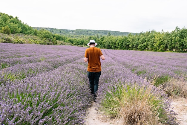 Foto uomo che cammina attraverso un campo di lavanda