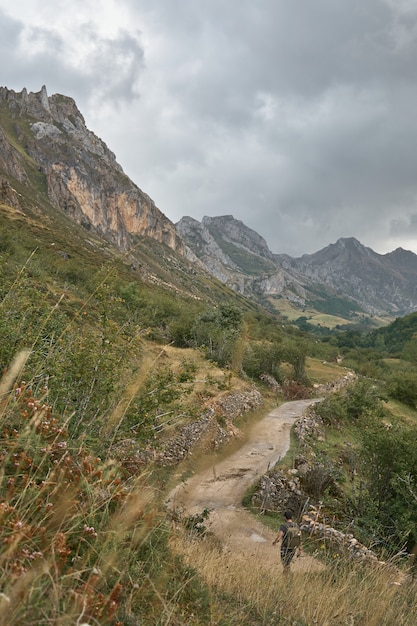 man walking through a valley in Somiedo