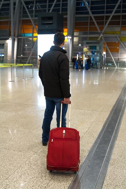 空港で荷物を持って歩く男