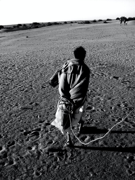 Man walking with rope on desert photo