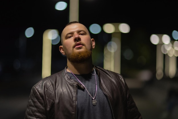 Photo a man walks along the streets city portrait of a young guy against the background of an artfully dec