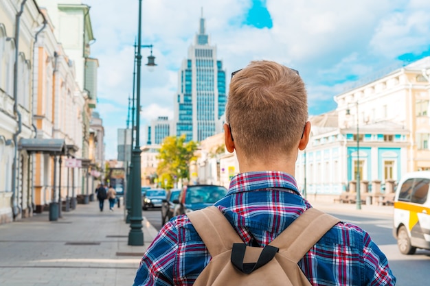 A man walks along a summer Moscow street with a view of the high rise business center