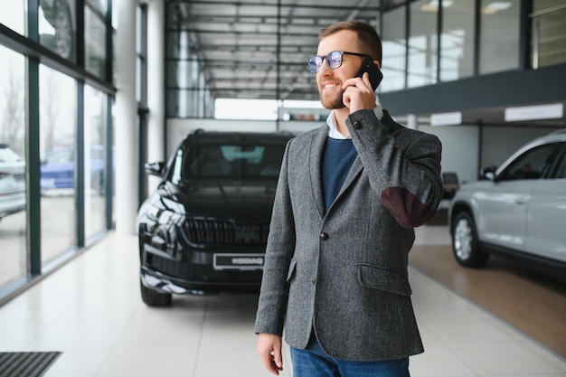 A man walks around a car dealership and chooses a new car