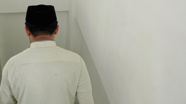 A man walks down the stairs in a white shirt.