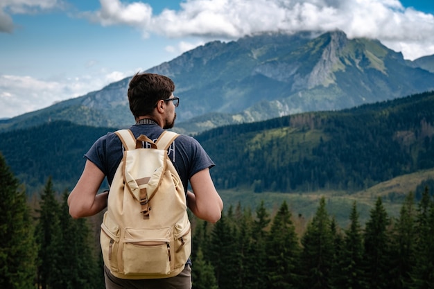 Man wandelen in de bergen met zware rugzak