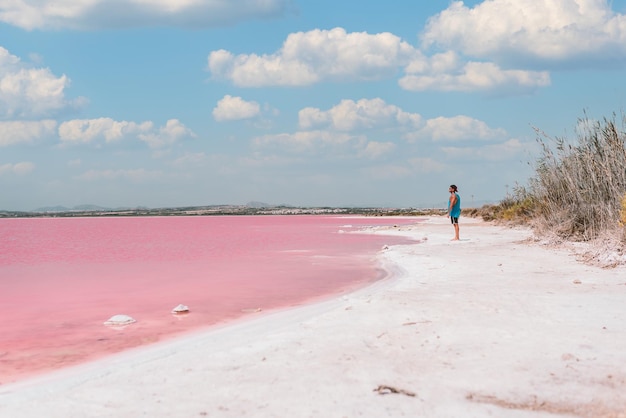 Man wandelen langs het strand in de buurt van roze zee