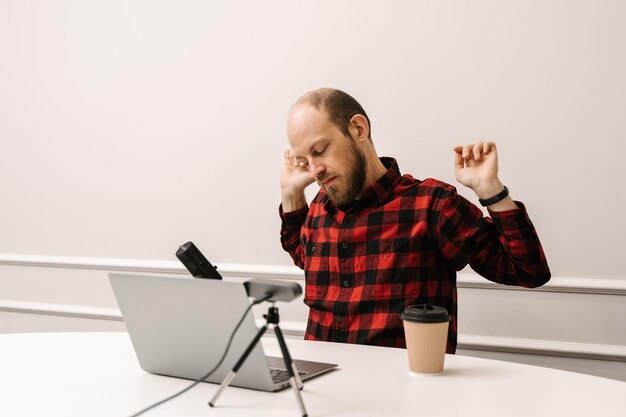 Photo man warming up while sitting at a laptop at a remote job