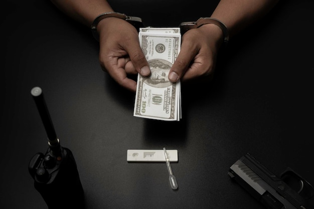 A man was handcuffed on a black table. He is being tested for drugs. His test results were positive and he gave the police money to release. Corruption, bribery, illegal transactions