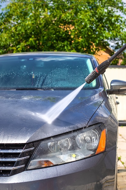 A man washes his car on the street