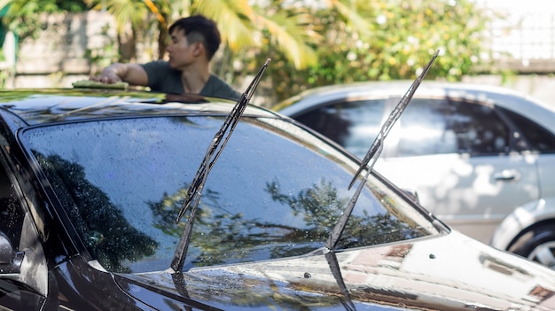 Photo man washing the black car.