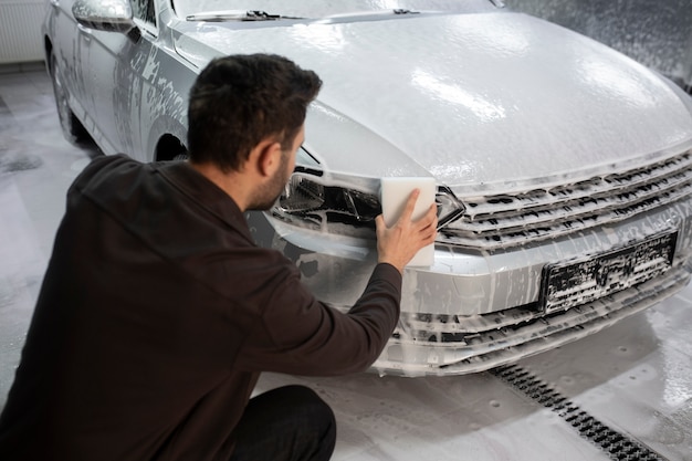 Man washing the car headlight