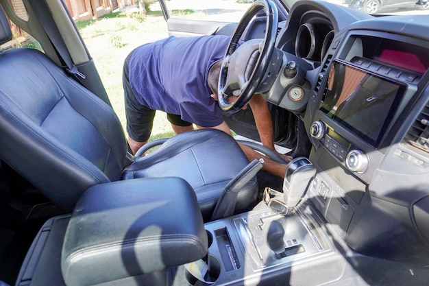 Foto uomo che lava l'auto con un lavandino a pressione, shampoo, spugne e asciugamani per auto in microfibra