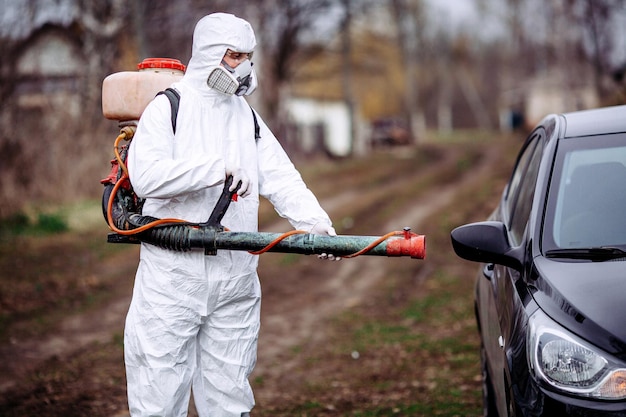 Uomo che lava l'auto con il concetto di coronavirus chimico covid 19 epidemia