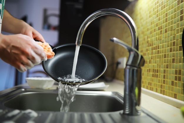 Man washing dish in sink at restaurantPeople are washing the dishes too Cleaning solution