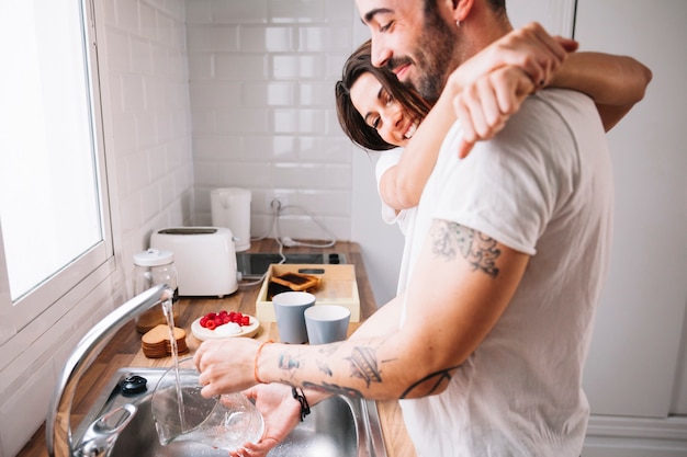 Man washing dishes for woman