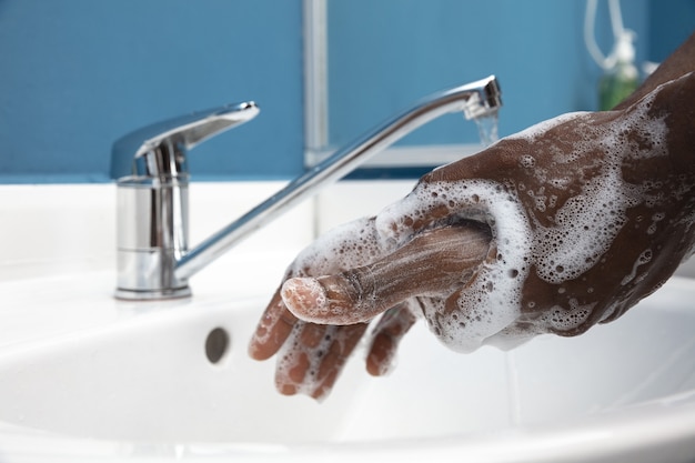 Man washing hands carefully with soap and sanitizer, close up. Prevention of pneumonia virus spreading, protection against coronavirus pandemia. Hygiene, sanitary, cleanliness, disinfection. Safety.