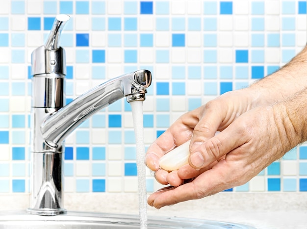 Man Washing of hands with soap under running water