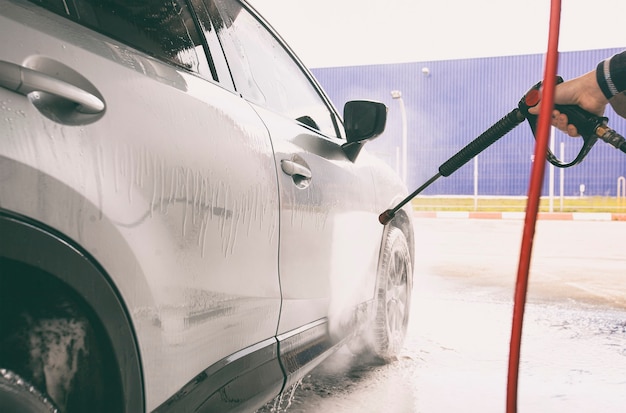 L'uomo che lava la sua auto nell'autolavaggio self-service