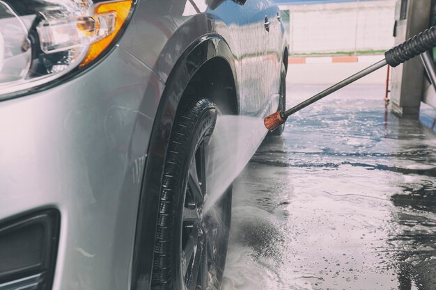 L'uomo che lava la sua auto nell'autolavaggio self-service