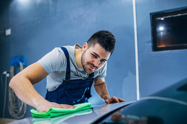 Man washing his car in a workshop