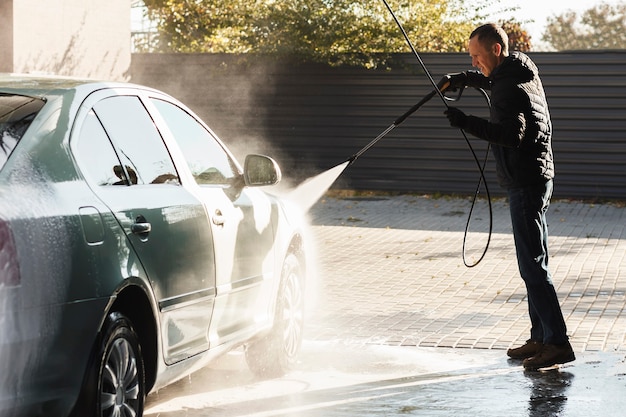 Man wast auto bij selfservice carwash