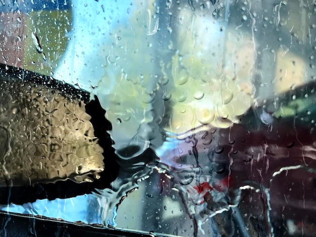 man wast auto in auto servis center, raam glas nat van wassen waterdruppels stromen