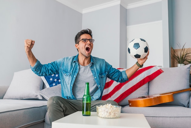 Foto uomo che guarda il calcio a casa