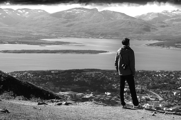 ノルウェーのフィヨルドの風景の背景のhdで見ている男