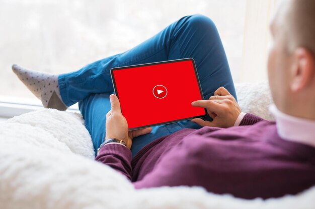 Man watching online videos on his tablet at home