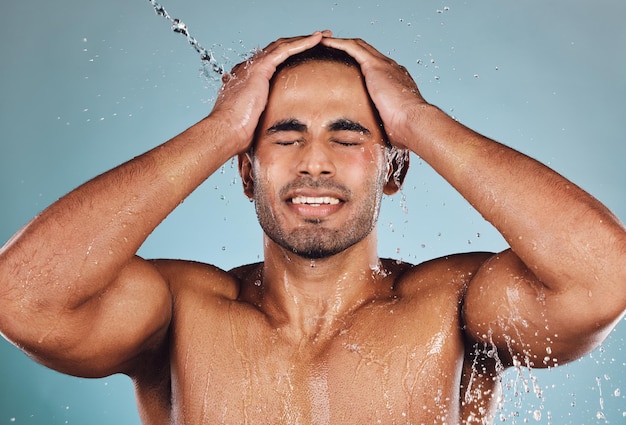 Фото Мужчина всплеск воды и мытье лица для ухода за кожей, гигиена, гидратация или душ на фоне студии
