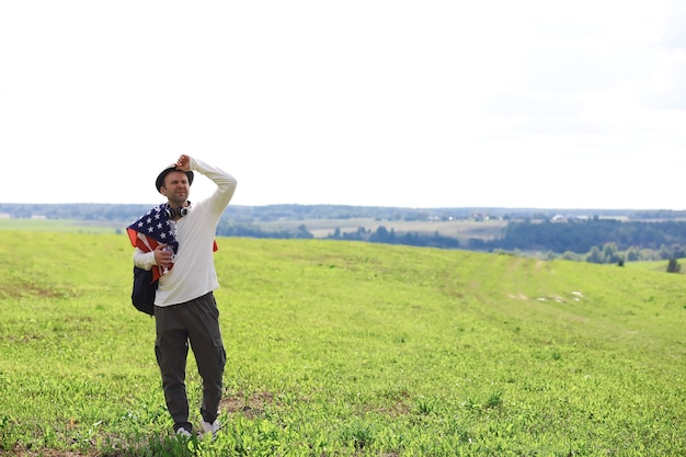 Man waving American flag standing in grass farm agricultural field , holidays, patriotism, pride, freedom, political parties, immigrant