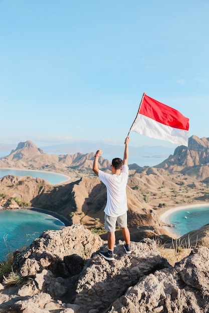 A man waving indonesia flag at labuan bajo with pride