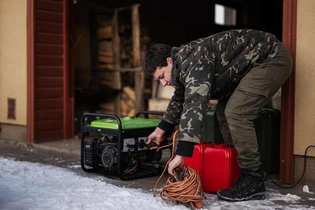 Man wear in military jacket with gasoline portable mobile backup standby generator