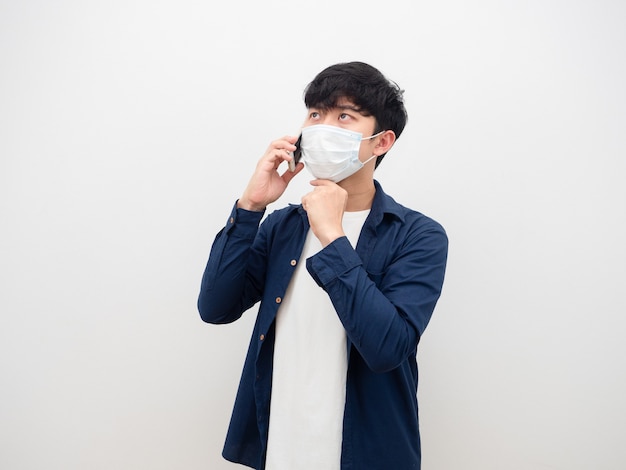 Man wearin mask serious face talkin with mobile phone white background