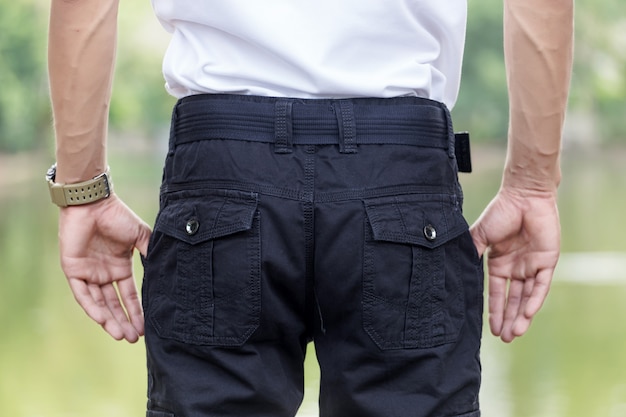 L'uomo indossa pantaloni cargo neri e in piedi nel parco naturale