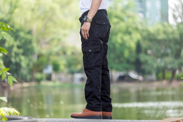 Man wearing black cargo pants and standing in the nature park