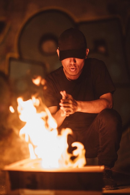 Man wearing black crewneck shirt and black jeans in front of flame photo